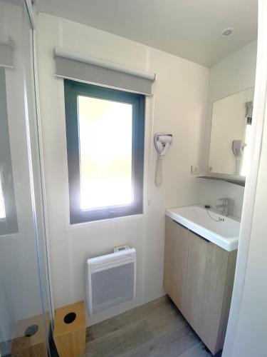 a bathroom with a sink and a window at Camping du Chêne - proche de Nantes in Saint-Julien-de-Concelles
