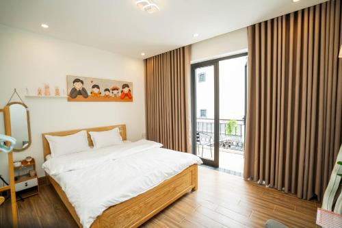 a bedroom with a bed and a large window at Dimori homestay in Hue