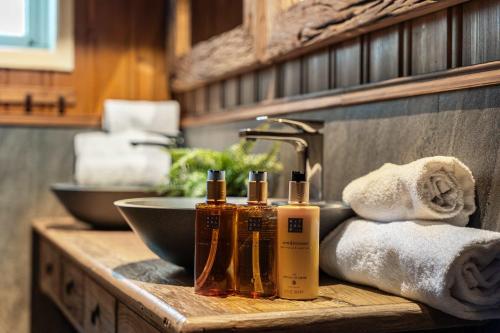 a bathroom counter with a sink with bottles of soap and towels at TH589- Large ski-in out chalet in Trysilfjell with sauna, hottub in Hovi
