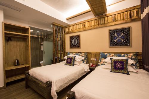 a bedroom with two beds and a window at Chong Chong Guesthouse in Zhangjiajie