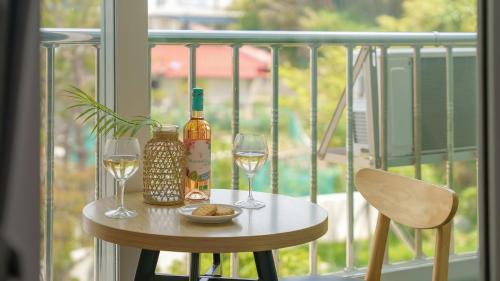 a table with two glasses and a bottle of wine at Gangneung Glad Pension in Gangneung
