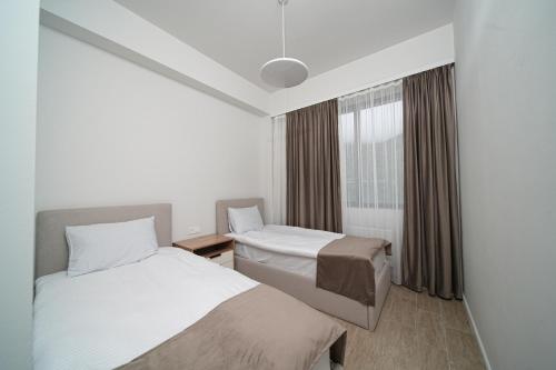 a hotel room with two beds and a window at Verinn Apart Hotel in Dilijan