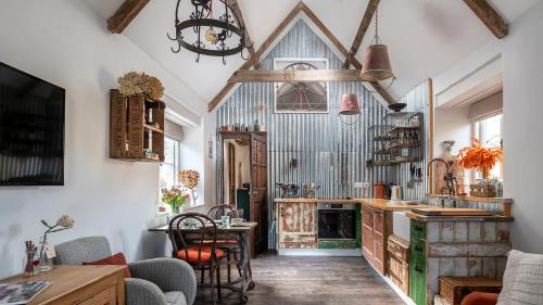 a living room with a table and chairs and a kitchen at Filly Island in South Cerney