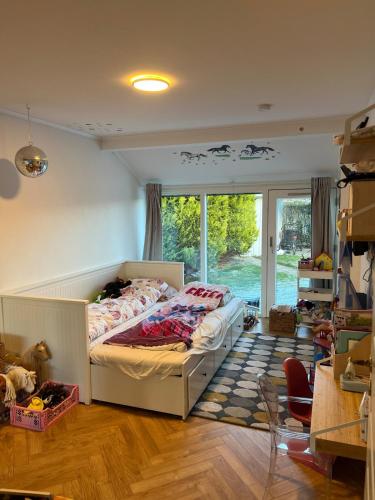 a bedroom with a bed and a large window at Large townhouse Odense in Odense