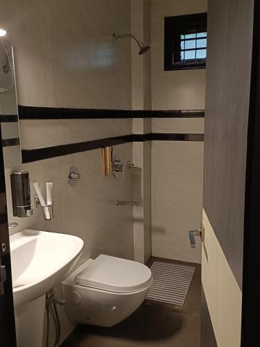 a bathroom with a white toilet and a sink at Hotel Paryatak in Namchi