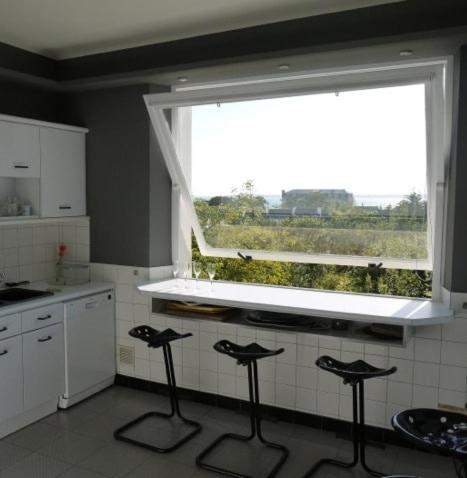 a kitchen with four stools in front of a window at Maison Ville - Plage - Concarneau in Concarneau
