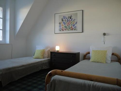 a bedroom with two beds and a picture on the wall at Maison Ville - Plage - Concarneau in Concarneau