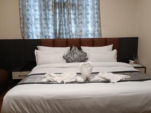 a bed with white sheets and towels on it at Hotel Paryatak in Namchi