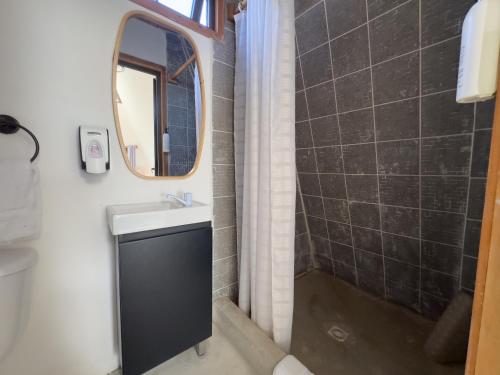 a bathroom with a sink and a mirror at Arena Hostel in El Paredón Buena Vista