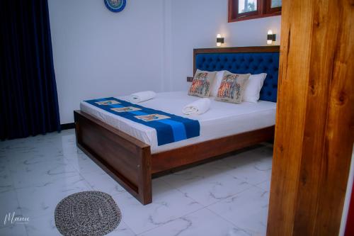 a bed with a wooden frame in a room at Coco Leaf Apartment with Private Pool Near the Beach in Hikkaduwa