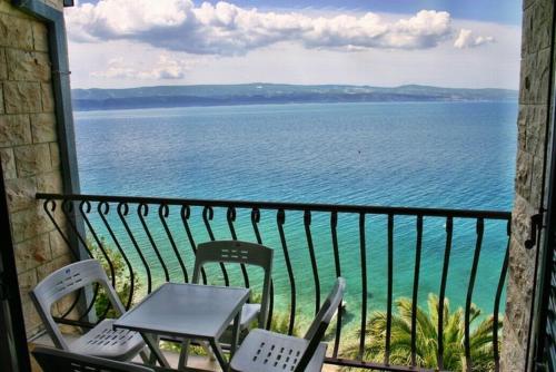 a table and chairs on a balcony overlooking the ocean at 230 MESTRO in Stanići