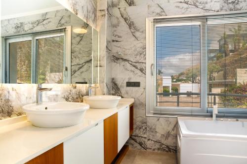 a bathroom with two sinks and a window at Villa Azure Heaven in Turgutreis