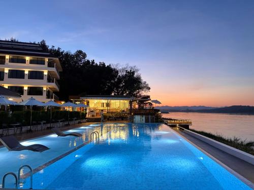 a large swimming pool next to a building with the water at Chiangkhan River Mountain Resort in Chiang Khan