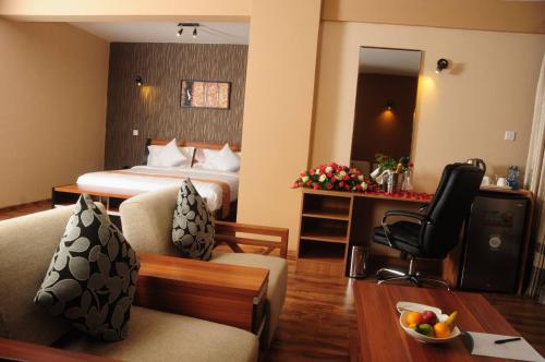 ナイロビにあるWe Hotel and Suitesのベッドと机があるホテルの部屋