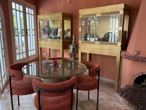 a dining room with a glass table and chairs at Palais Elya in Rabat