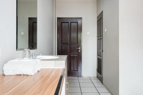 a bathroom with a sink and a mirror at RedDoorz Plus at Hotel Ulin Samarinda in Samarinda