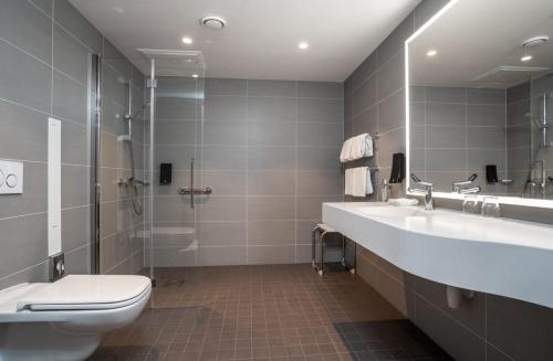 a bathroom with a toilet and a sink and a shower at Thon Hotel Brønnøysund in Brønnøysund