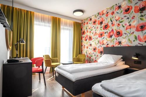 a hotel room with two beds and a desk at Thon Hotel Brønnøysund in Brønnøysund