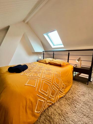 a bedroom with a yellow bed with a window at L'escale Barbieux in Croix