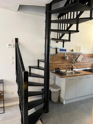 a spiral staircase in a kitchen with a sink at L'escale Barbieux in Croix
