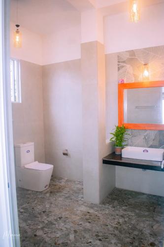 a bathroom with a toilet and a sink at Coco Leaf Apartment with Private Pool Near the Beach in Hikkaduwa
