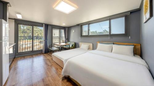 two beds in a room with two windows at Samcheok Lamer Pension in Samcheok