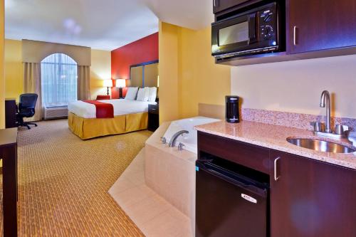 a hotel room with a bed and a kitchen with a sink at Holiday Inn Express Nashville-Opryland by IHG in Nashville