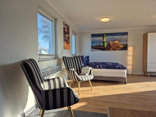 a bedroom with two chairs and a bed and a window at Ostseecamping am Salzhaff in Pepelow
