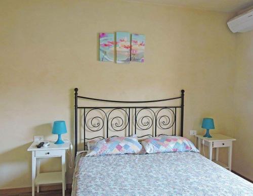 1 dormitorio con 1 cama y 2 mesas con lámparas azules en Petitui, en San Biagio della Cima