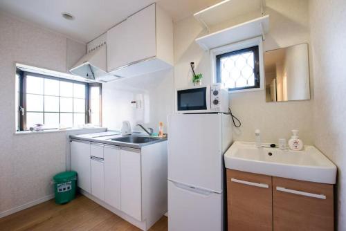 a small kitchen with a white refrigerator and a sink at Hiregasaki, Nagareyama 2号 CB0439 in Nagareyama