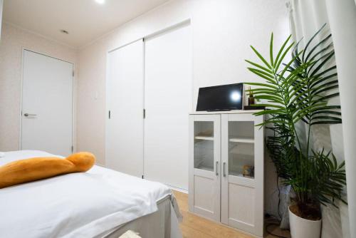 a bedroom with a bed and a tv on a cabinet at Hiregasaki, Nagareyama 2号 CB0439 in Nagareyama