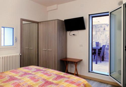 a bedroom with a bed and a cabinet with a television at B&B Il Campanile in Barletta