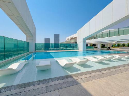 a large building with a swimming pool with white chairs at Vogue Vacation Homes, Al Wasl 1 Residences Near Zabeel Park and World Trade Centre, Two Bedroom Apartment with Balcony and City View, Access to all Amenities, Walkable to Max Fashion Metro Station in Dubai