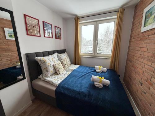 a small bedroom with a bed with towels on it at Skoczybruzda Apartamenty in Chmielno