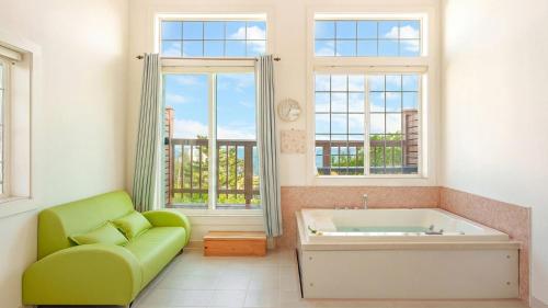 a bathroom with a green couch and a tub at Gangleung laimbichipensyeon in Gangneung