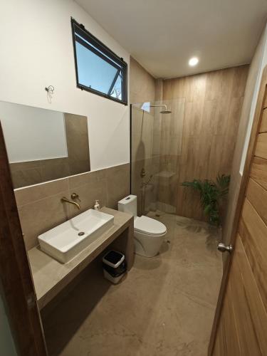 a bathroom with a sink and a toilet and a window at Ganesha Mouse House in Ko Phangan