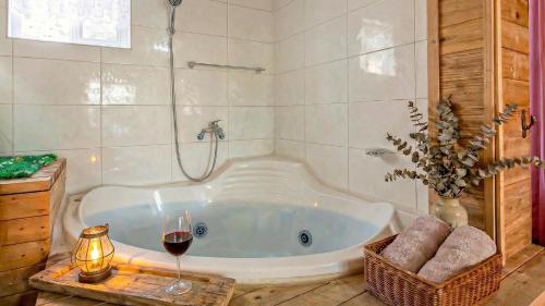 a bathroom with a tub with a glass of wine at Youngheungdo Roma Spa Pension in Incheon