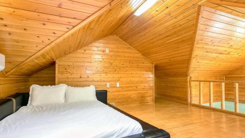 a bedroom with a bed in a wooden attic at Youngheungdo Roma Spa Pension in Incheon