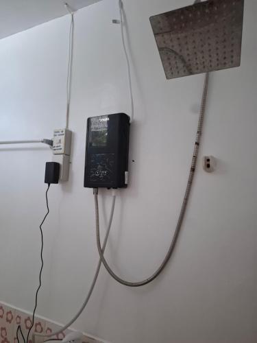 a tv with a cord hooked up to a wall at Imari's Apartment in San Isidro