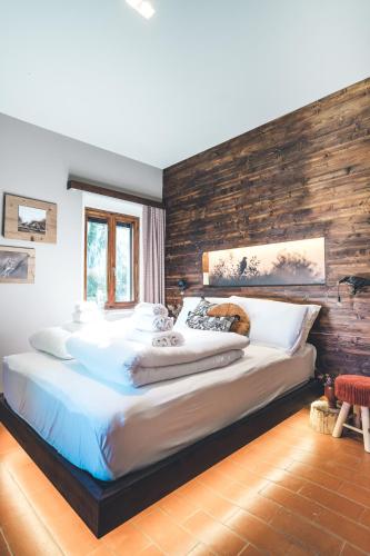 a large bed in a bedroom with a wooden wall at Rifugio Pian di Rocchi in Corniolo