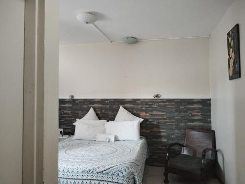 a bedroom with a bed with a brick wall at Concord Christian Guesthouse in Durban
