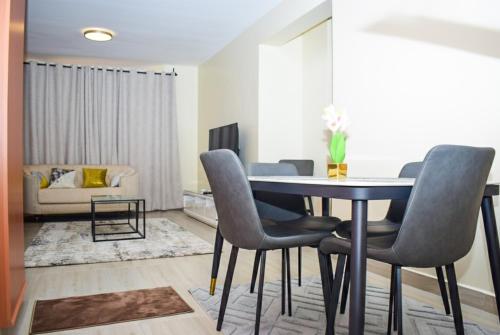 a living room with a dining room table and chairs at Zinari Comfort Homes in Nakuru