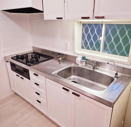 a kitchen with a sink and a stove at Itoshima STAY YAMAGA Keya in Itoshima
