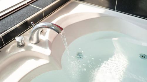 a white bath tub with water coming out of it at Geoje Gaonara Pension in Geoje