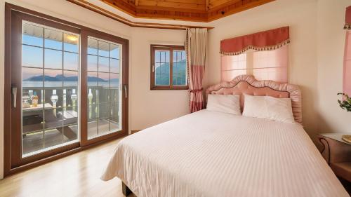 a bedroom with a bed and a large window at Geoje Gaonara Pension in Geoje