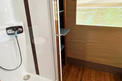 a bathroom with a shower and a door with a window at Lodge Mini-Wood in Les Rochettes
