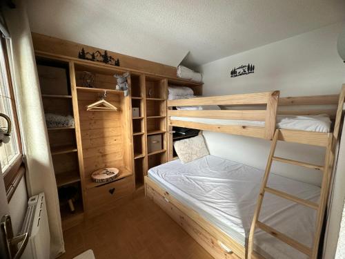 a bedroom with two bunk beds and a ladder at L'Ecrin des Myrtilles - Appartement cosy - Piscine et vue montagne - Alpes - Val d'Arly - Aravis et Beaufortain in Flumet