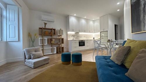 a living room with a blue couch and a kitchen at FERREIRA'S HOUSE Viana do Castelo in Viana do Castelo