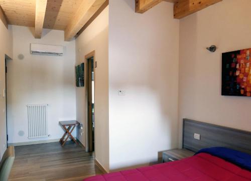 a bedroom with a red bed and a wooden floor at B&B Il Campanile in Barletta