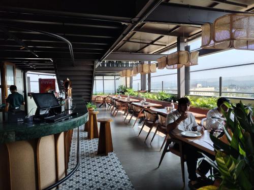 a restaurant with tables and chairs and people sitting at them at Myspace Chindanur Comforts in Chitradurga